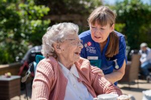 A-resident-and-carer-enjoy-time-spent-together-at-The-Orders-of-St-John-Care-Trust-300x200